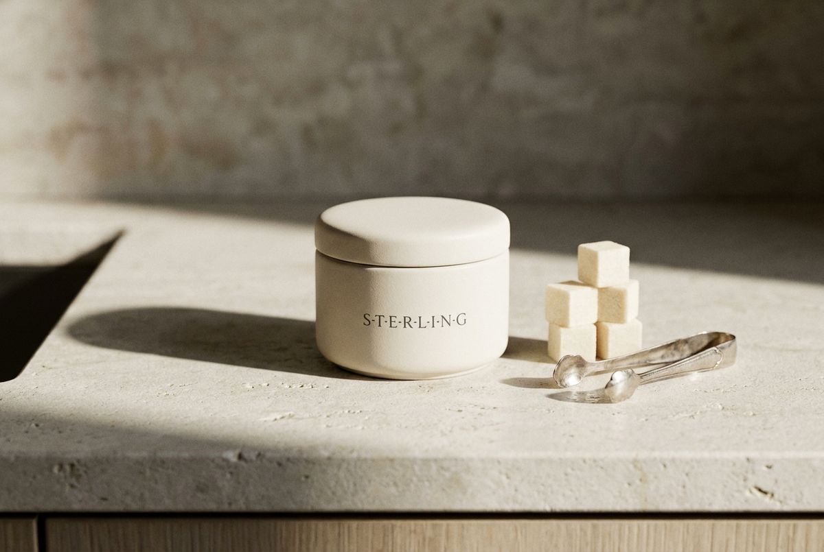 The Sterling tin with cubes and silver tongs on a limestone counter
